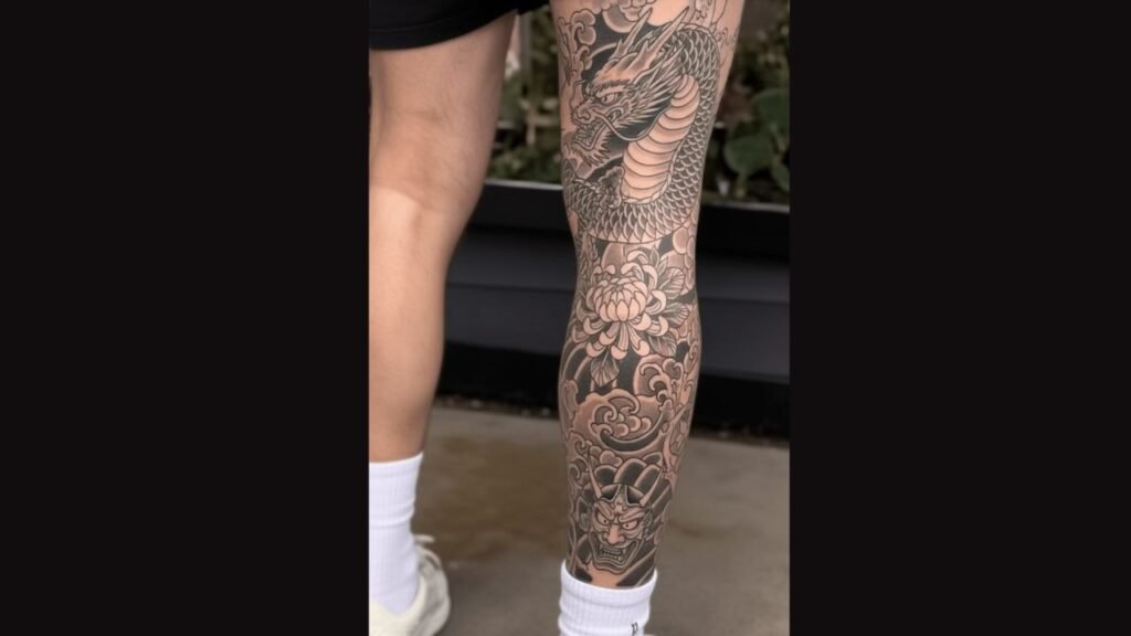 Men upper leg tattoo featuring a bold dragon and geometric design on the outer thigh, highlighting muscle shape and strength.